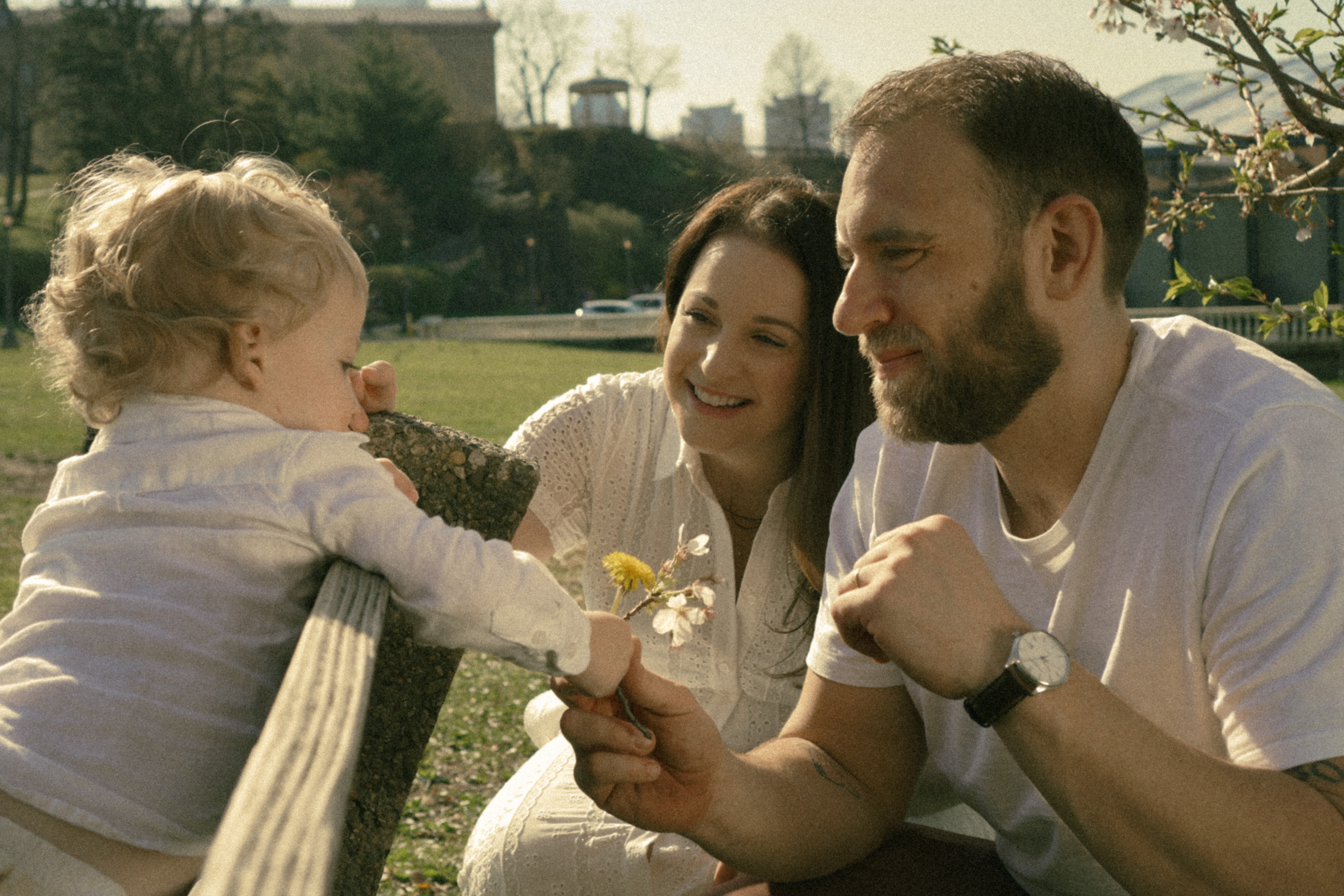 A little boy handing a flower to his dad during a golden hour family session in Philadelphia